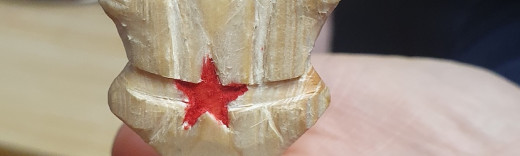 Das Logo des BDP, aus einem Stock geschnitzt, wird auf einer Hand gehalten